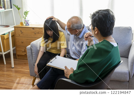 Parents telling the psychologist about family or child problems. Depressed girl and her parent or grandpa having session with psychiatrist in clinic. Parents telling the psychologist about family or child problems. Depressed girl and her parent or grandpa having session with psychiatrist in clinic. 122194847