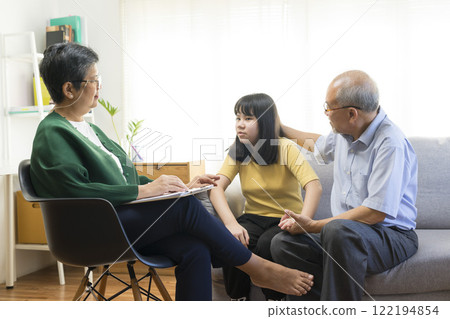 Parents telling the psychologist about family or child problems. Depressed girl and her parent or grandpa having session with psychiatrist in clinic. 122194854