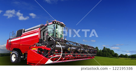 Combine harvester and agricultural machinery against the banner background of a farmer's field. Combine harvester and agricultural machinery against the banner background of a farmer's field. 122195386