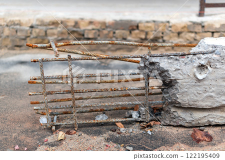 Rusted metal reinforcement bars coupled with chipped concrete fragments. Deterioration, decay, neglect in infrastructure development, or corrosion impacts on construction materials over time. Rusted metal reinforcement bars coupled with chipped concrete fragments. Deterioration, decay, neglect in infrastructure development, or corrosion impacts on construction materials over time. 122195409