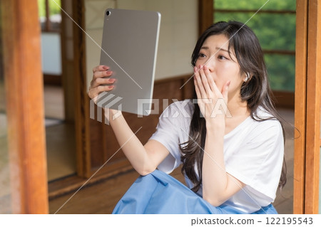年輕女子看著平板電腦，印象深刻 122195543