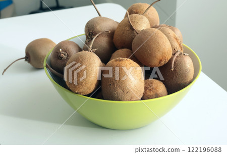 Group of kiwi with tails from home garden in bowl. Eco-friendly pure natural product. Group of kiwi with tails from home garden in bowl. Eco-friendly pure natural product. 122196088