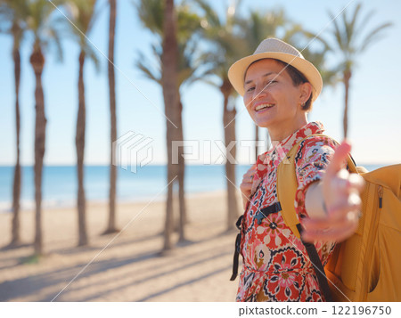 Woman in dress strolls through colorful streets of Spanish coastal town of La Vila Joiosa or Villajoyosa. sunny winter atmosphere highlights charm of Mediterranean architecture and quiet seaside life 122196750