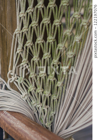 Close-up of a weathered rope hammock, showcasing intricate knotwork and texture. High quality photo 122197076