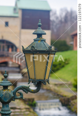 vintage lantern with ornate details, casting warm glow against blurred backdrop. High quality photo 122197079