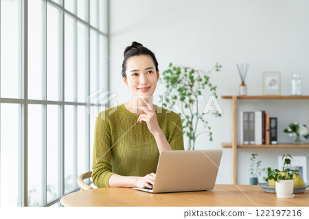 A young woman using a computer at home 122197216