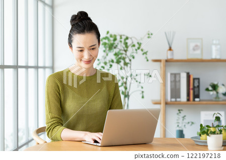 A young woman using a computer at home 122197218