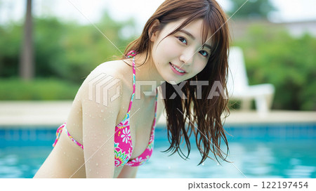 A woman in a swimsuit with a gentle smile and refreshing splashes of water 122197454