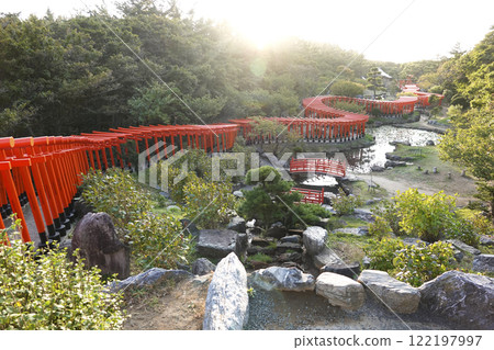 A thousand torii gates twisting like dragons bathed in the setting sun A thousand torii gates twisting like dragons bathed in the setting sun 122197997
