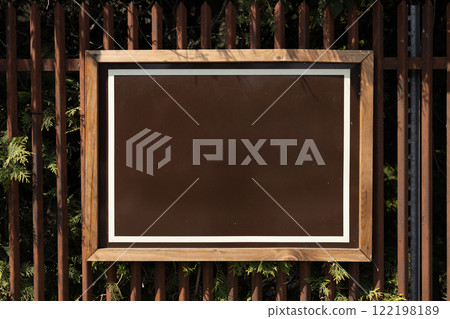 Blank brown billboard sign mockup in the urban environment. Clear urban glued advertising canvas. Billboard advertisement advertiser on steel fence. Mock up 122198189