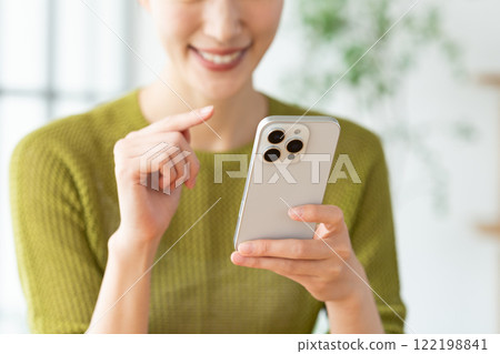 Young woman using a smartphone at home Young woman using a smartphone at home 122198841