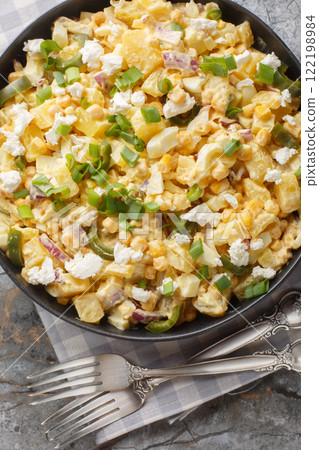 Mexican corn potato salad with eggs, onions and pickled jalapeno peppers close-up in a bowl. Vertical top view 122198984