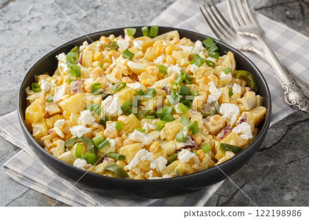 Mexican Corn Potato Salad made with corn kernels in a creamy mixture of mayonnaise, sour cream, cheese closeup on the plate. Horizontal 122198986