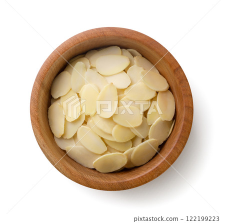 Almond flakes in a wooden plate close-up on a white. Top view Almond flakes in a wooden plate close-up on a white. Top view 122199223