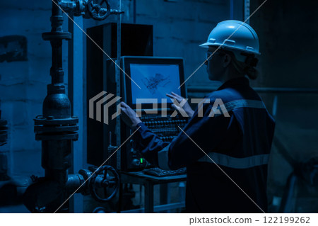 Engineer Monitoring Industrial Equipment in a Modern Facility 122199262