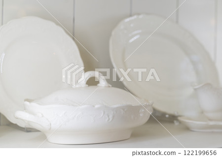 Closeup of white ceramic serving ware on shelf 122199656