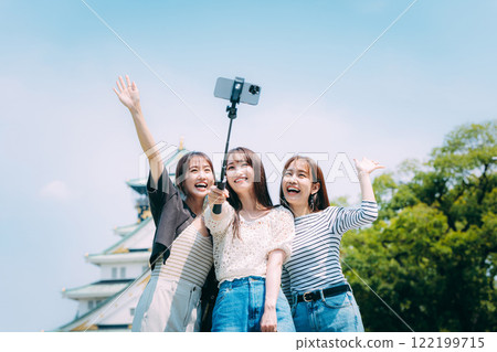 Three girls taking a selfie in front of Osaka Castle 122199715