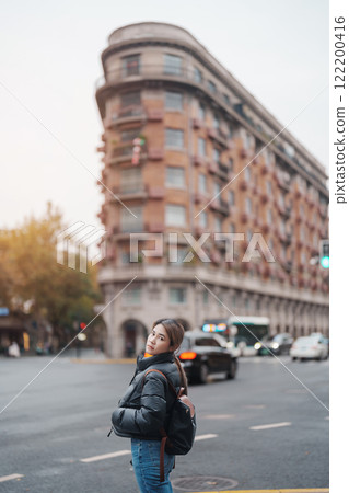 woman traveler visiting in Shanghai, China. Female Tourist with backpack sightseeing Wukang Mansion with Wukang Road and Middle Huaihai Road. landmark and popular for tourism attractions in Shanghai woman traveler visiting in Shanghai, China. Female Tourist with backpack sightseeing Wukang Mansion with Wukang Road and Middle Huaihai Road. landmark and popular for tourism attractions in Shanghai 122200416