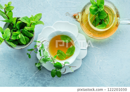Mint tea. A cup of peppermint tea with fresh mint leaves and a teapot 122201030