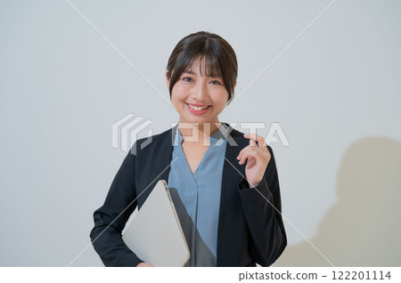 A smiling Japanese woman holding a laptop 122201114