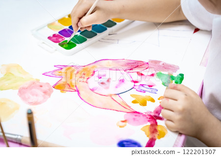 child painting a picture with school supplies, preschool child painting, child drawing a rainbow, child doing homework. 122201307