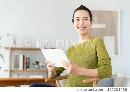 Young woman using a tablet at home 122201466