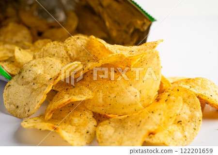Potato chips, delicious spicy for crips, thin slice deep fried snack fast food in open bag. Potato chips, delicious spicy for crips, thin slice deep fried snack fast food in open bag. 122201659