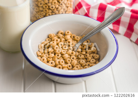 Sweet honey cereal rings in bowl on white table. 122202616