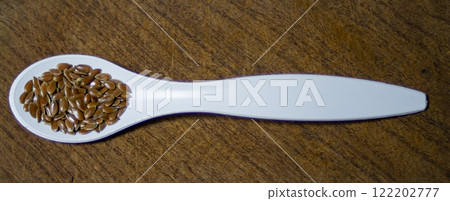 White spoon with linseed on wooden background..Healthy food. 122202777