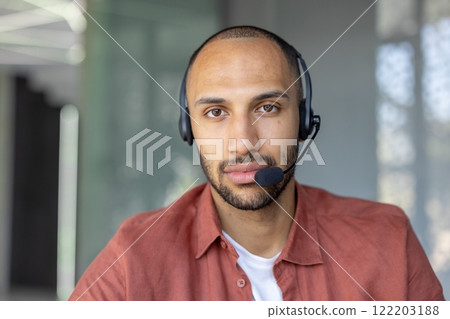 Man in a professional office setting wearing a headset, conveying communication and focus. 122203188