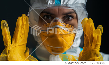 Healthcare worker in PPE with a concerned gaze. 122203380