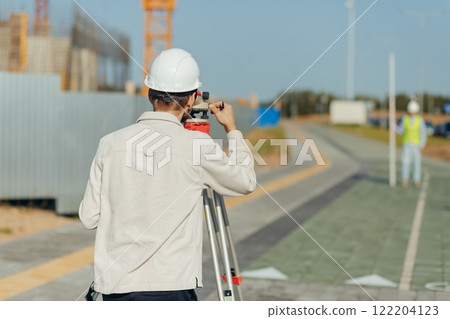 Team survey construction engineer use level survey camera. Team survey construction engineer use level survey camera. 122204123