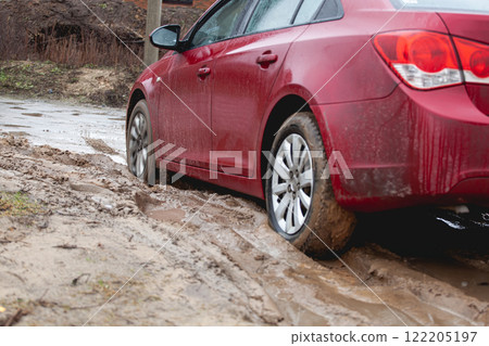 Car stuck in the mud, car wheel in dirty puddle, rough terrain 122205197