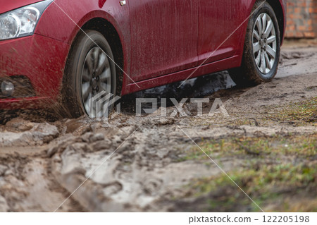 Car stuck in the mud, car wheel in dirty puddle, rough terrain 122205198
