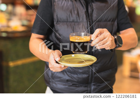 Man's hand holding coffee cup in cafe. Man's hand holding coffee cup in cafe. 122206181