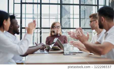 Colleagues at meeting in boardroom, sitting at table together, sharing ideas, discussing project strategy. 122206537