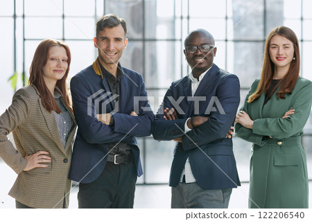 a team of businessmen stand in a trendy office with their arms crossed. business concept 122206540
