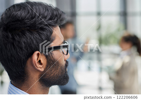 concentrated businessman with beard and glasses looks away 122206606