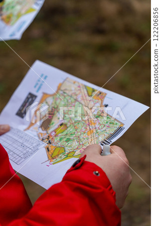 Athlete holding a map during orienteering competitions. 122206856