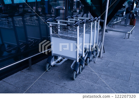 Luggage trolley at the airport terminal, empty space for advertising or public information, advertisement concept.  122207320