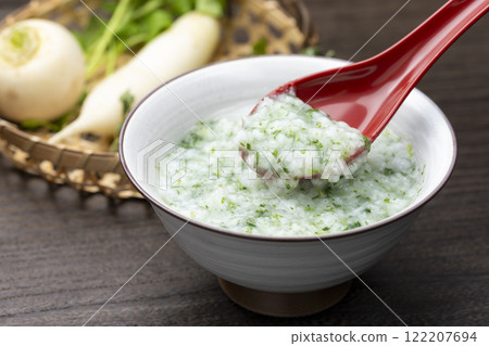 Rice porridge with seven herbs scooped up with a red spoon Rice porridge with seven herbs scooped up with a red spoon 122207694