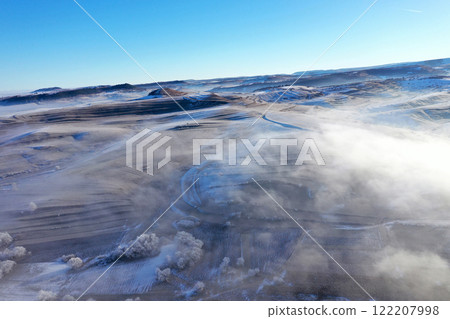 Aerial view of misty countryside hills at wintertime, morning fog above 122207998