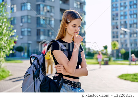 Sad unhappy teenage college student girl with backpack, outdoor, city background Sad unhappy teenage college student girl with backpack, outdoor, city background 122208153