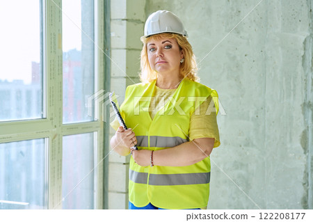 Portrait confident woman in safety vest hard hat at construction site 122208177