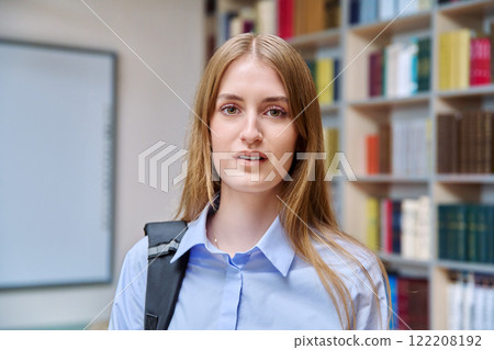 Headshot portrait of smiling teenage girl student, inside high school building 122208192