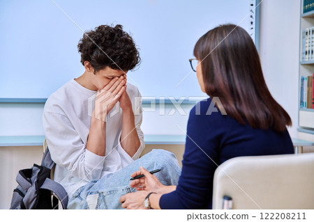 Psychologist working with young male college student in educational office Psychologist working with young male college student in educational office 122208211