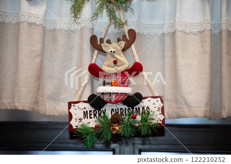 A Christmas figurine of a toy deer with the inscription Merry Christmas. Home decoration decor for Christmas holidays. 122210252