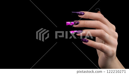Hand with a beautiful manicure on a black background. Nail design. Extended nails. 122210271