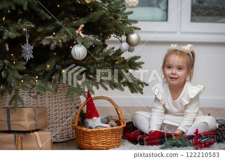 Happy little girl with Christmas tree toys in the Christmas room. The child is preparing for the Christmas holiday. Happy little girl with Christmas tree toys in the Christmas room. The child is preparing for the Christmas holiday. 122210583
