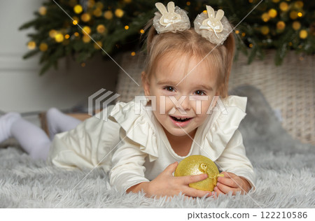 Happy girl with golden Christmas ball on Christmas Eve. Happy girl with golden Christmas ball on Christmas Eve. 122210586